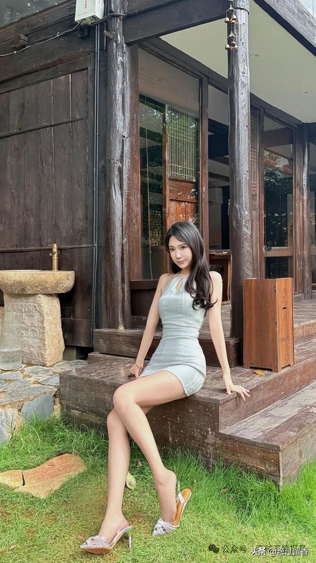优雅坐于古风庭院，浅灰色连衣裙与高跟鞋相得益彰，尽显时尚与古典的完美融合。