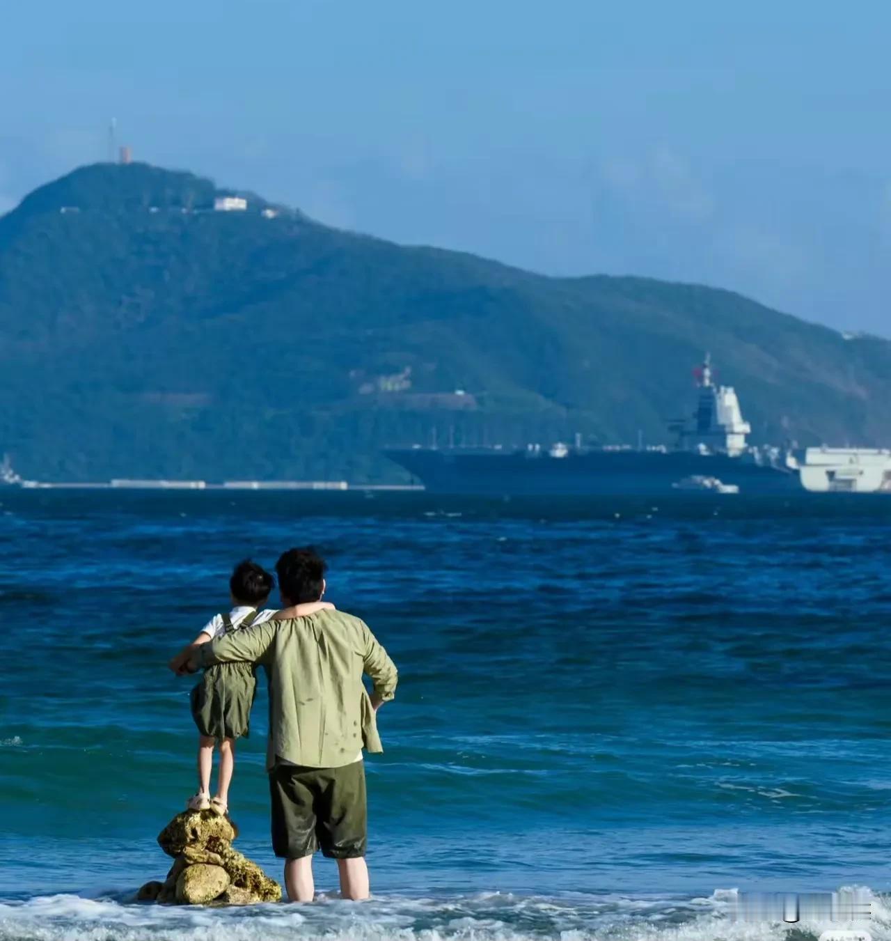 领着小孙站在碧蓝的大海里，领略一艘试航间正在出海的003航母，从此小孙知道这不是