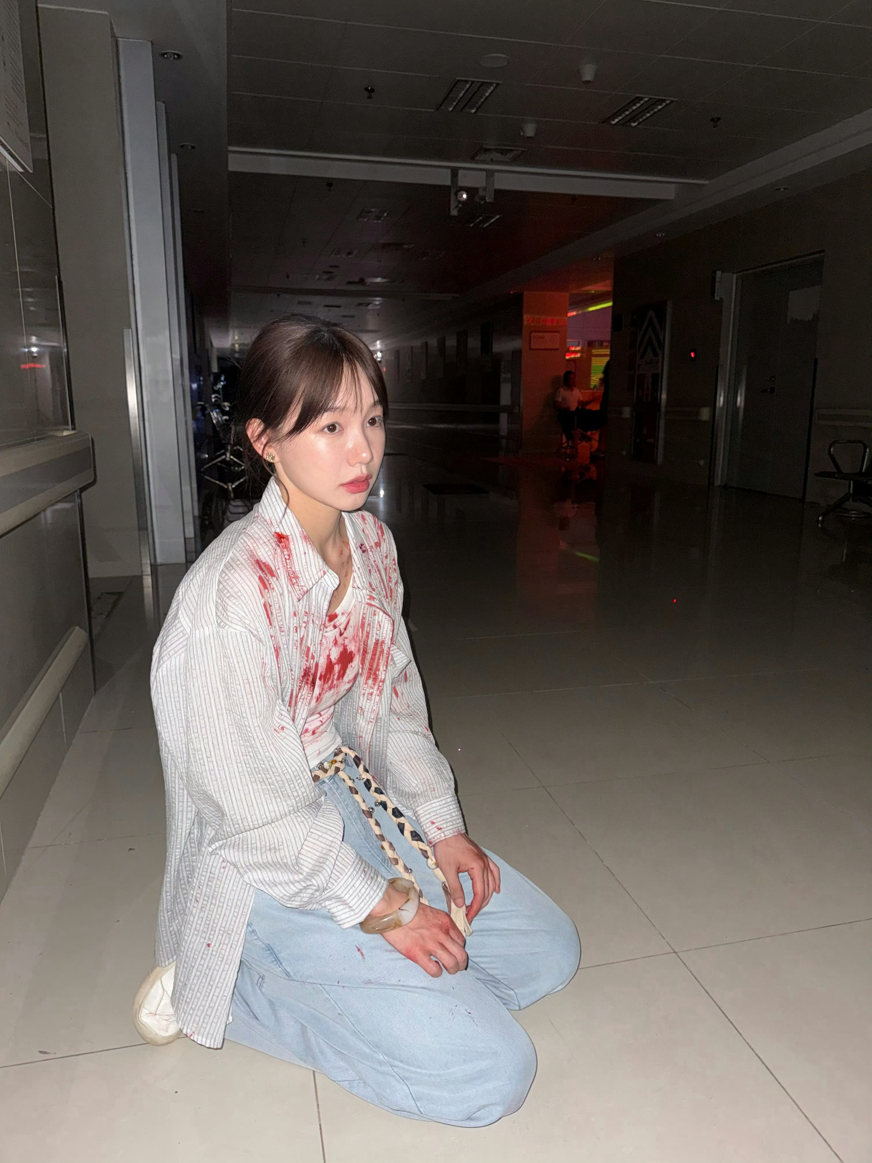 血迹点缀的白衬衫，跪地姿态透出破碎与倔强；脸上血迹妆与黑色皮衣相衬，眼神清冷又带