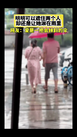 雨里的一把伞，成了最扎心的细节——
他撑着那把足够遮两人的粉伞走在前面，伞面稳稳