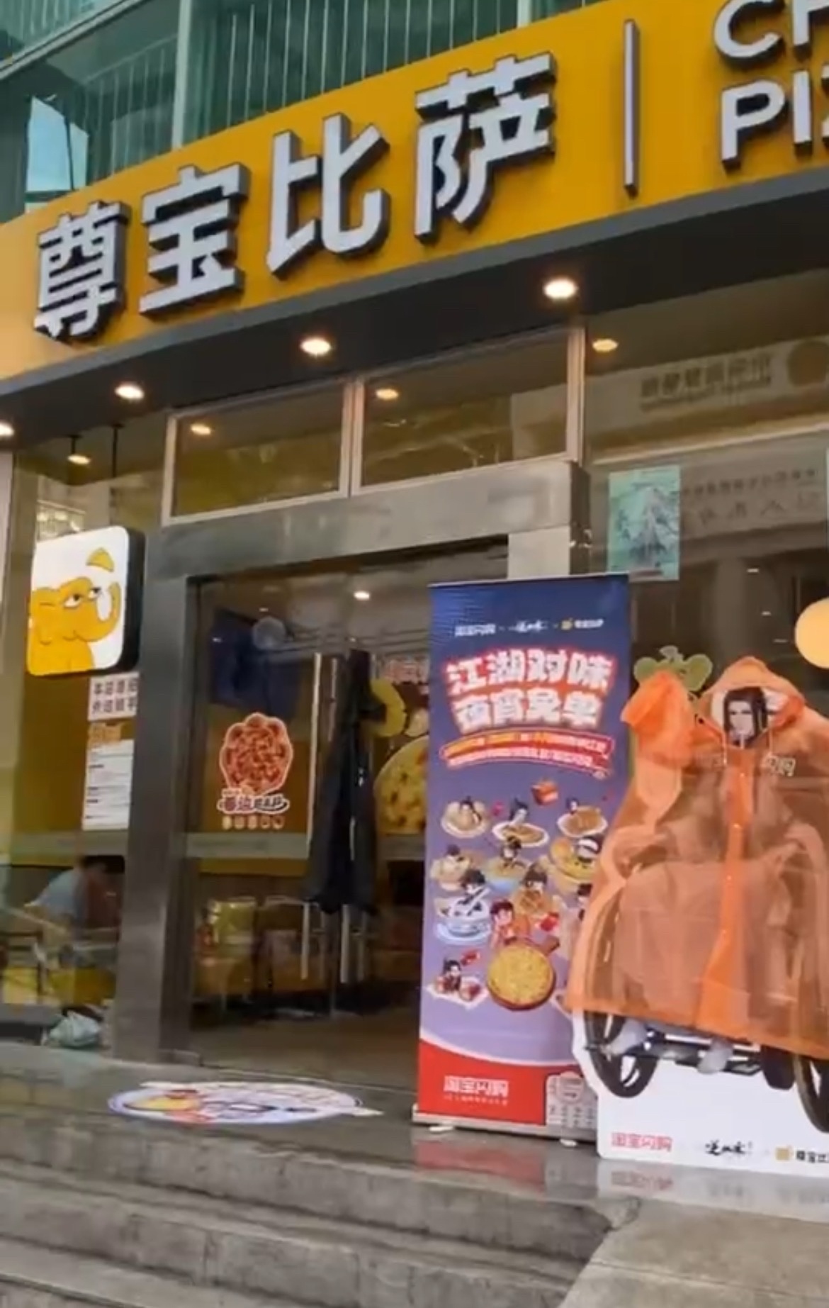 深圳街头偶遇穿雨衣的立牌淘宝闪购夜宵免单逆水寒淘闪夜市开张了初见雨中披雨衣的立牌