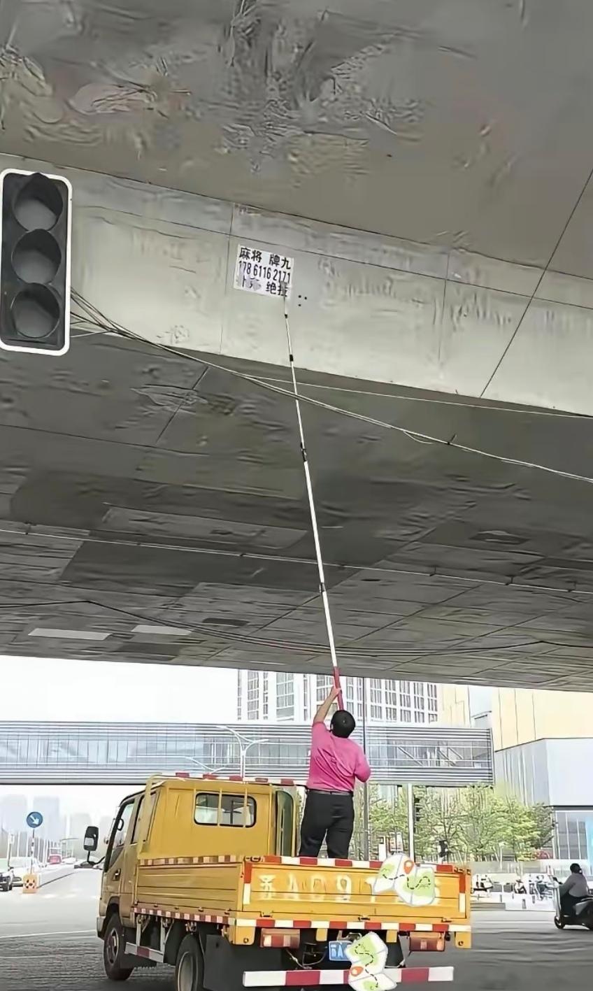 这小广告贴得位置也太刁钻了，桥洞高处一般人都够不着，不知道是怎么贴上去的，属实是