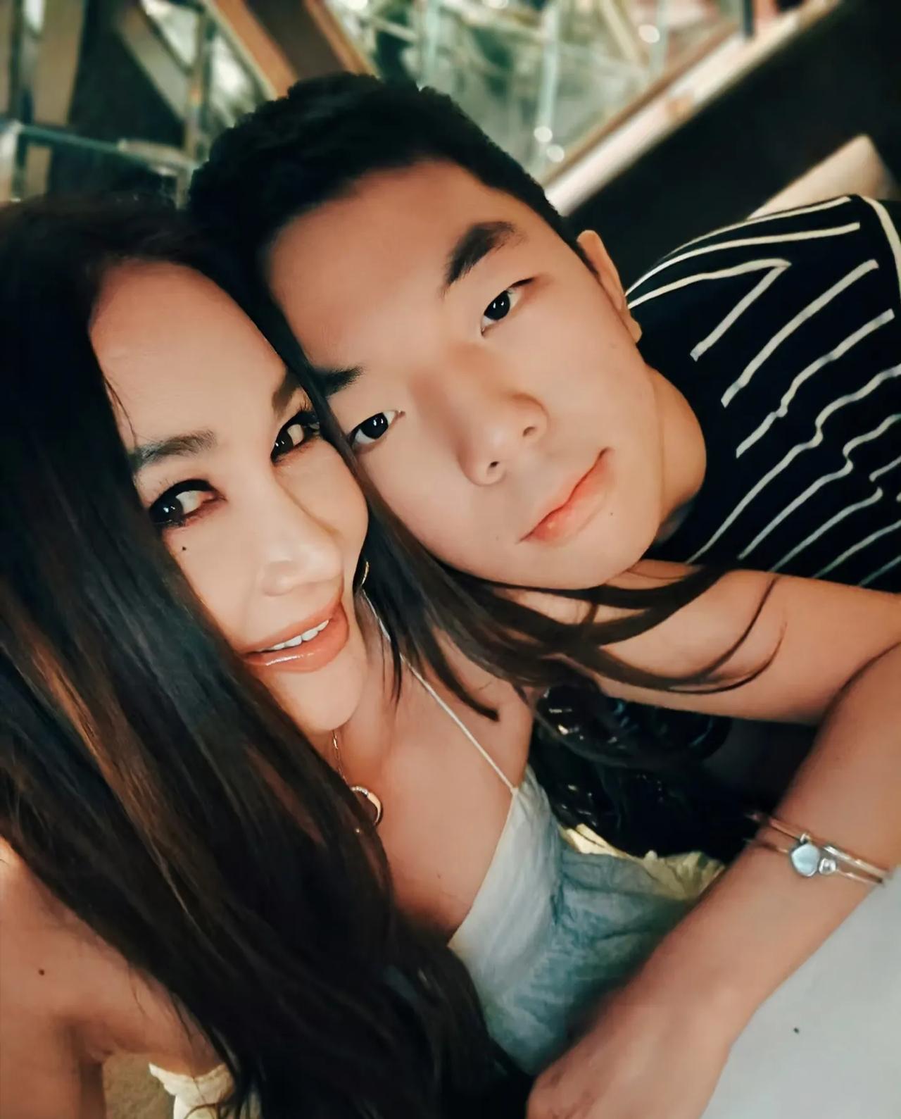 温碧霞和老公一起为养子庆祝生日，母子俩看起来好亲密，身体接触很自然，看对方的眼神
