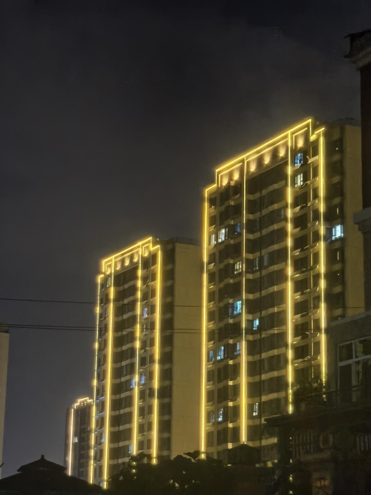 夜幕下的现代建筑，灯火辉煌，尽显都市繁华。
