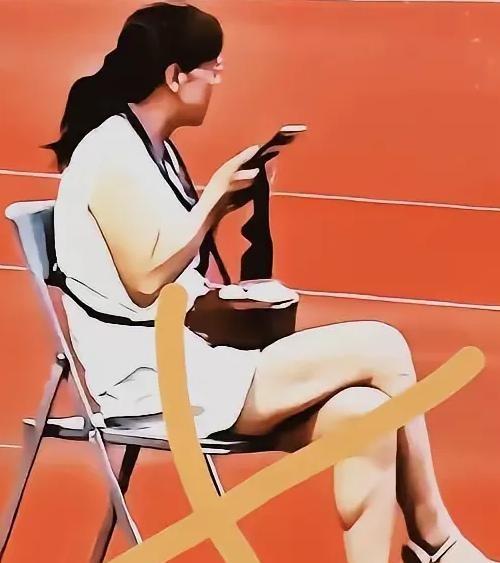 2026年7月18日，陇超足球联赛开幕式现场，一名女子在庄严的升旗仪式中坐着看手