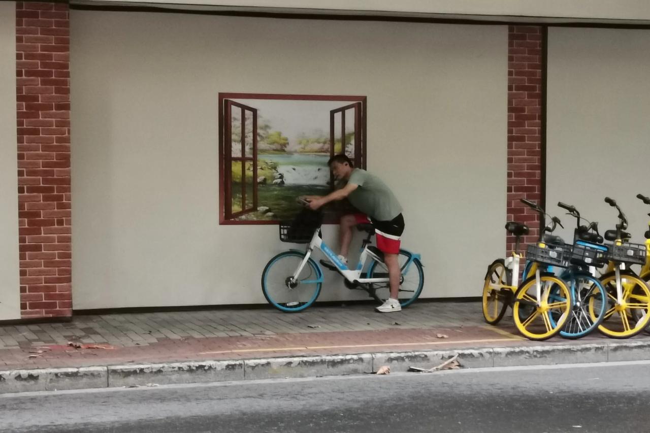 一个路人，停下自行车，一直在窗口，还以为他在看窗外。其实并不是，而是在看手机。而