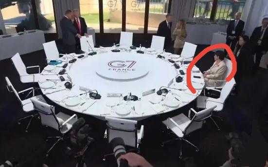 G7峰会一幕：会前，其他国家领导人在一旁交谈，只有高市早苗坐在圆桌上，还不时转动