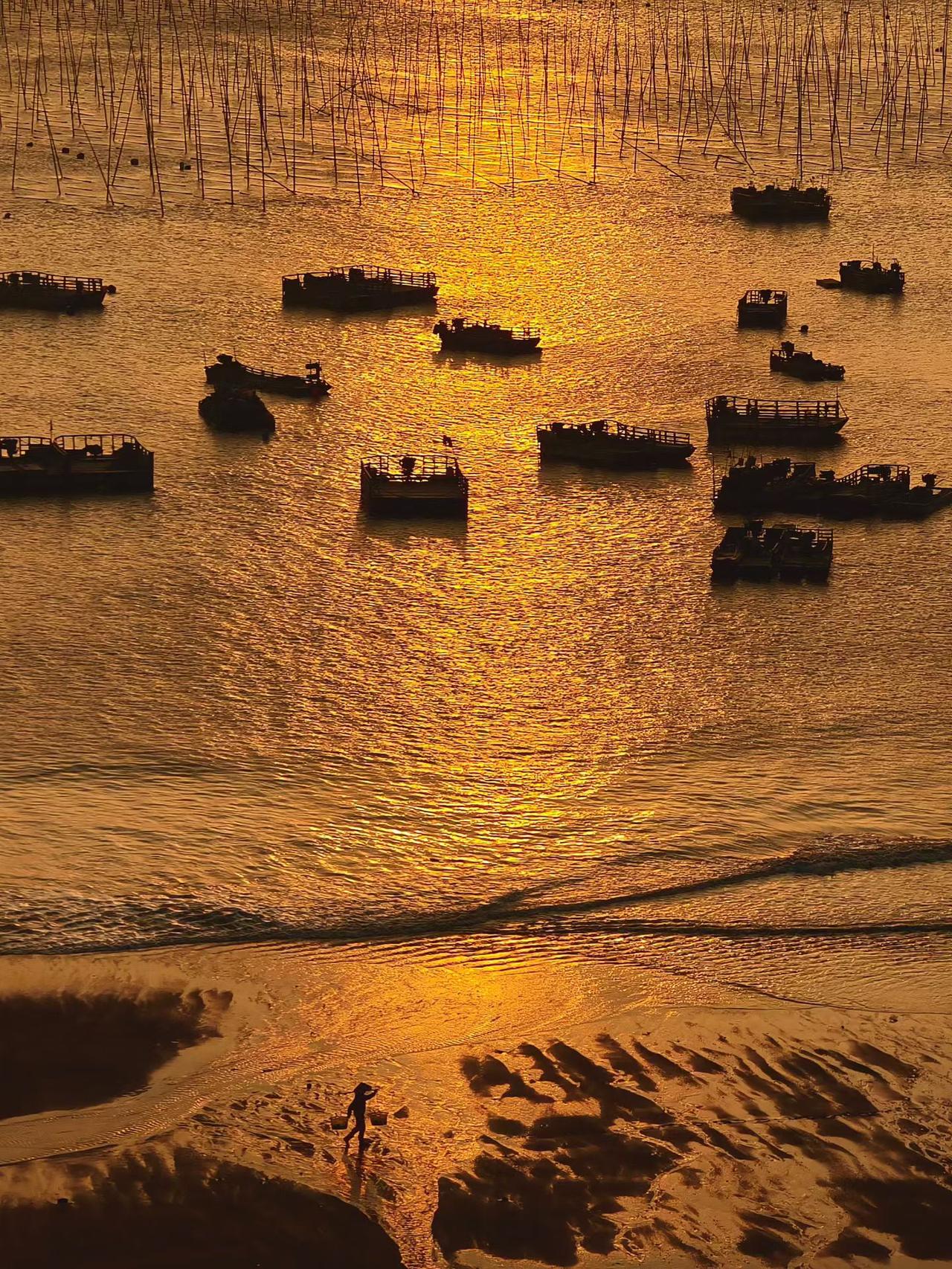夕阳下海面波光粦粦，渔船静静停泊，渔夫打鱼忙。