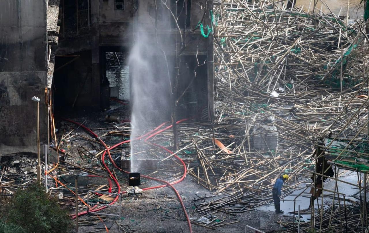 一名消防員向同袍何偉豪殉職的位置鞠躬