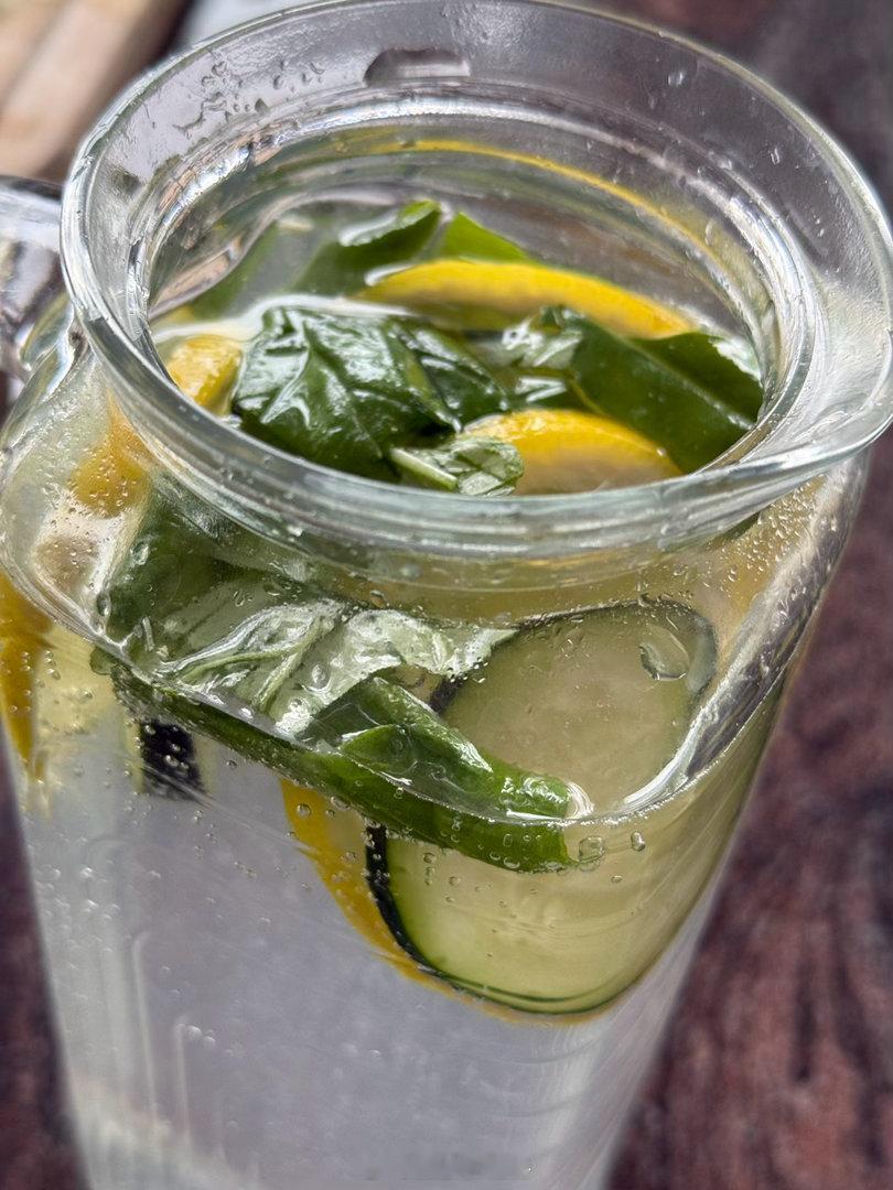 切几片黄瓜和几片柠檬，再挤出剩下的柠檬汁。手撕几片薄荷或者罗勒叶子。一壶水放在冰
