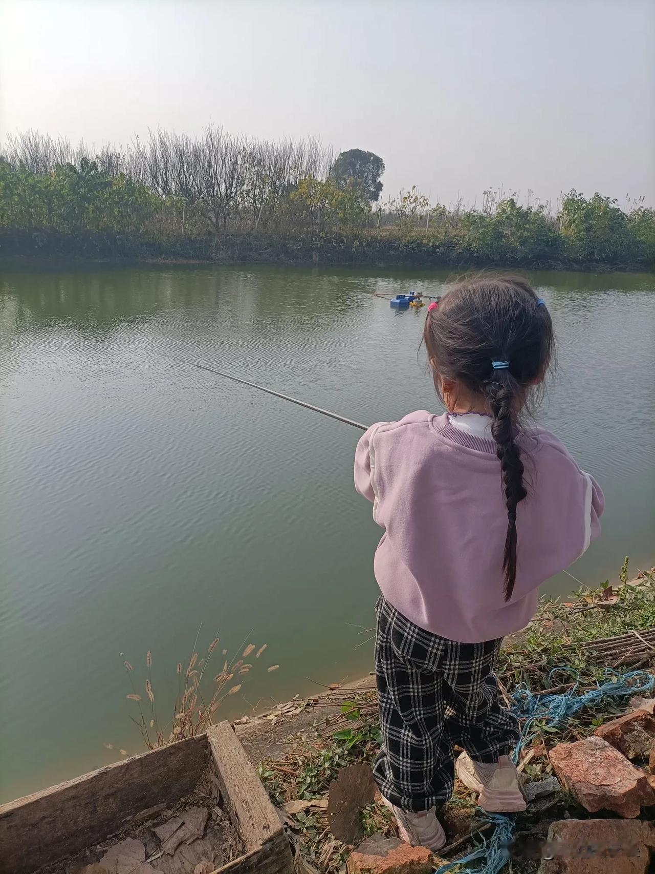 今天带小丫头去河边玩，没想到她盯着人家钓鱼竿挪不动脚，非闹着要试试。
这小不点攥