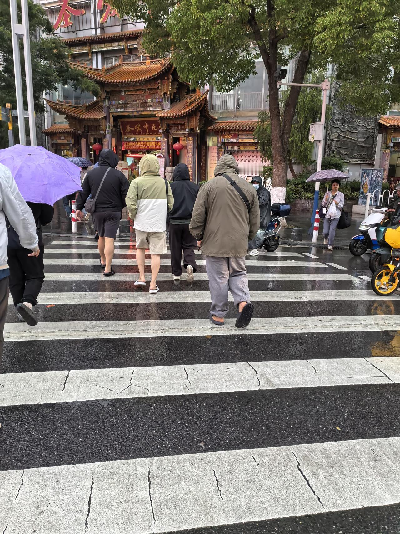 一看就是刚来昆明的游客吧，上身是把能避寒避雨的衣服全都穿上，脚上却都是托鞋清凉装