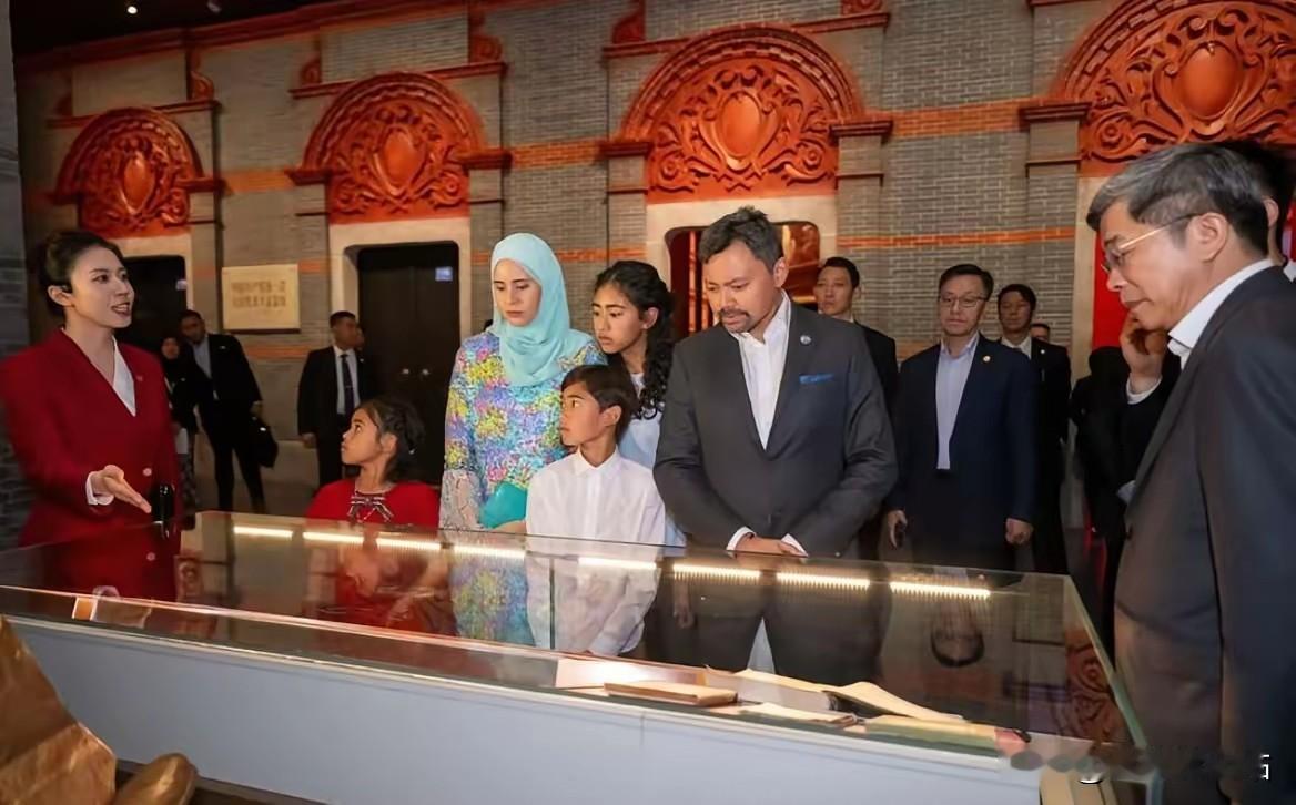 文莱王储比拉携带夫人及孩子们参观中国共产党历史展览馆，比拉儿子盯着讲解员姐姐听的