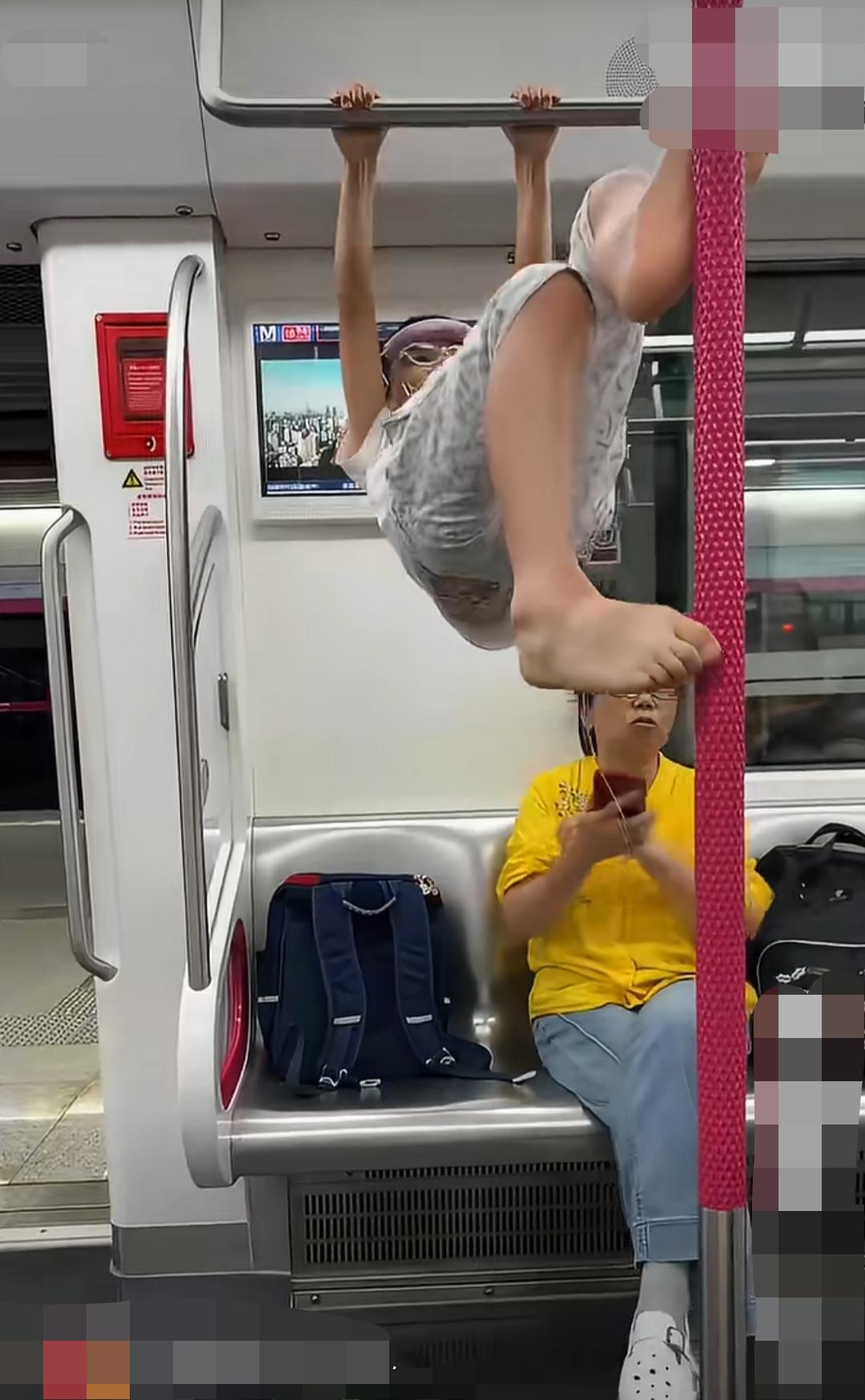 武汉。地铁车厢内。一名男孩脱鞋踩在座椅上，抓握车厢扶手攀爬翻腾，甚至将脚踩在立柱