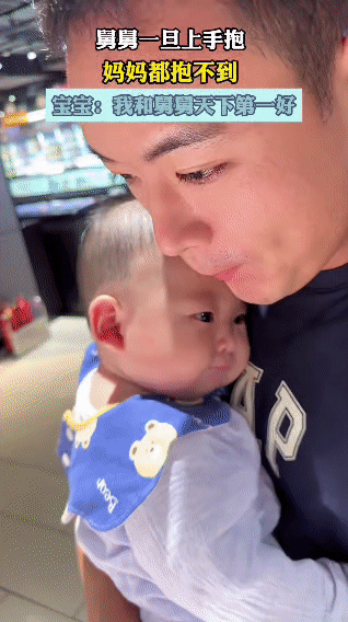 宝宝靠在舅舅怀里，小脑袋挨着舅舅，小手攥着舅舅的衣服，脸上是“舒服呀”的满足劲儿