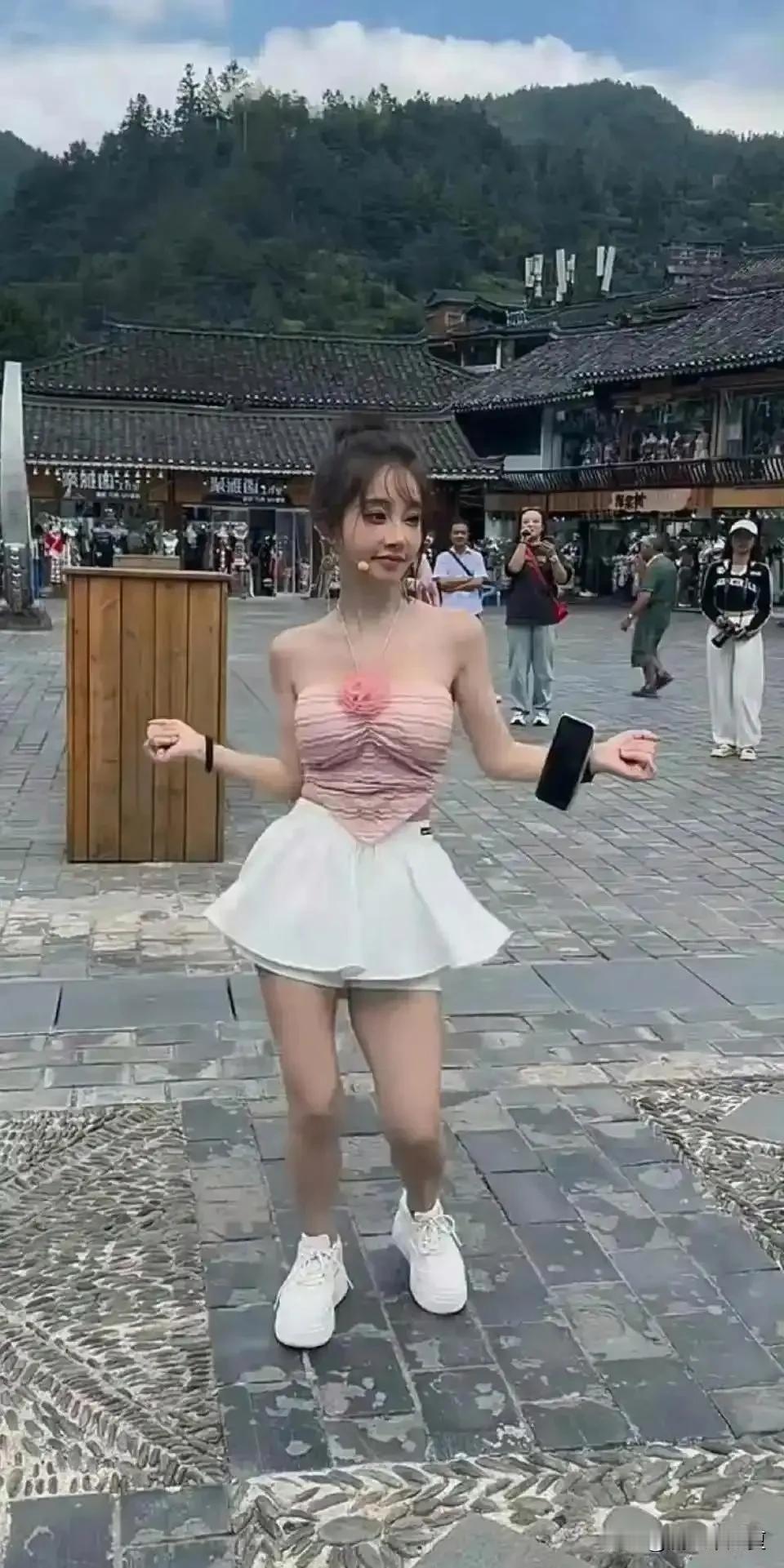 天呐，网红一姐冯提莫怎么变这个模样了？

穿着粉色抹胸上衣配白色短裙和运动鞋，手