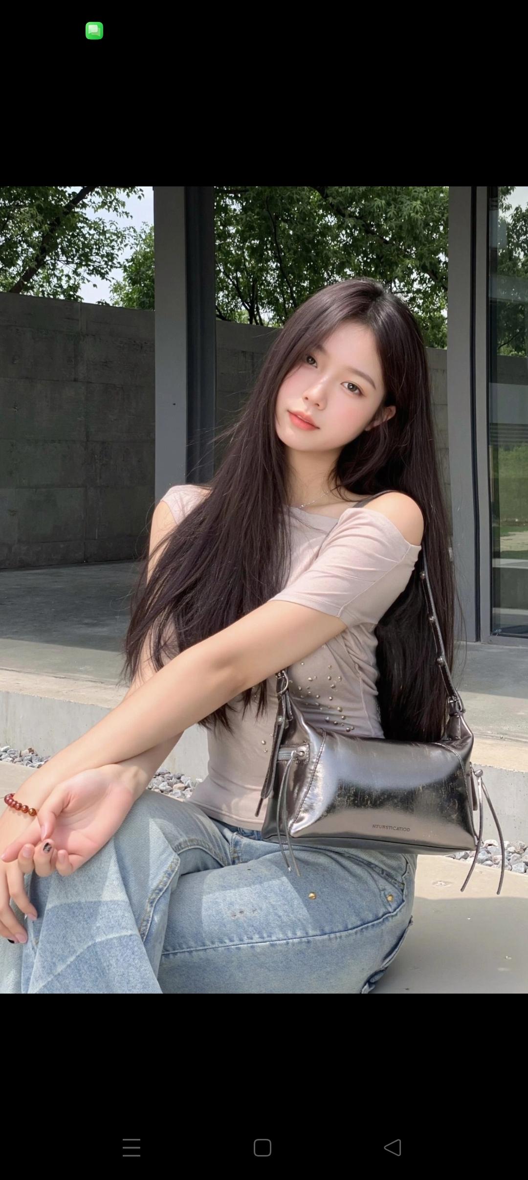 女孩坐在户外，看着镜头微笑。