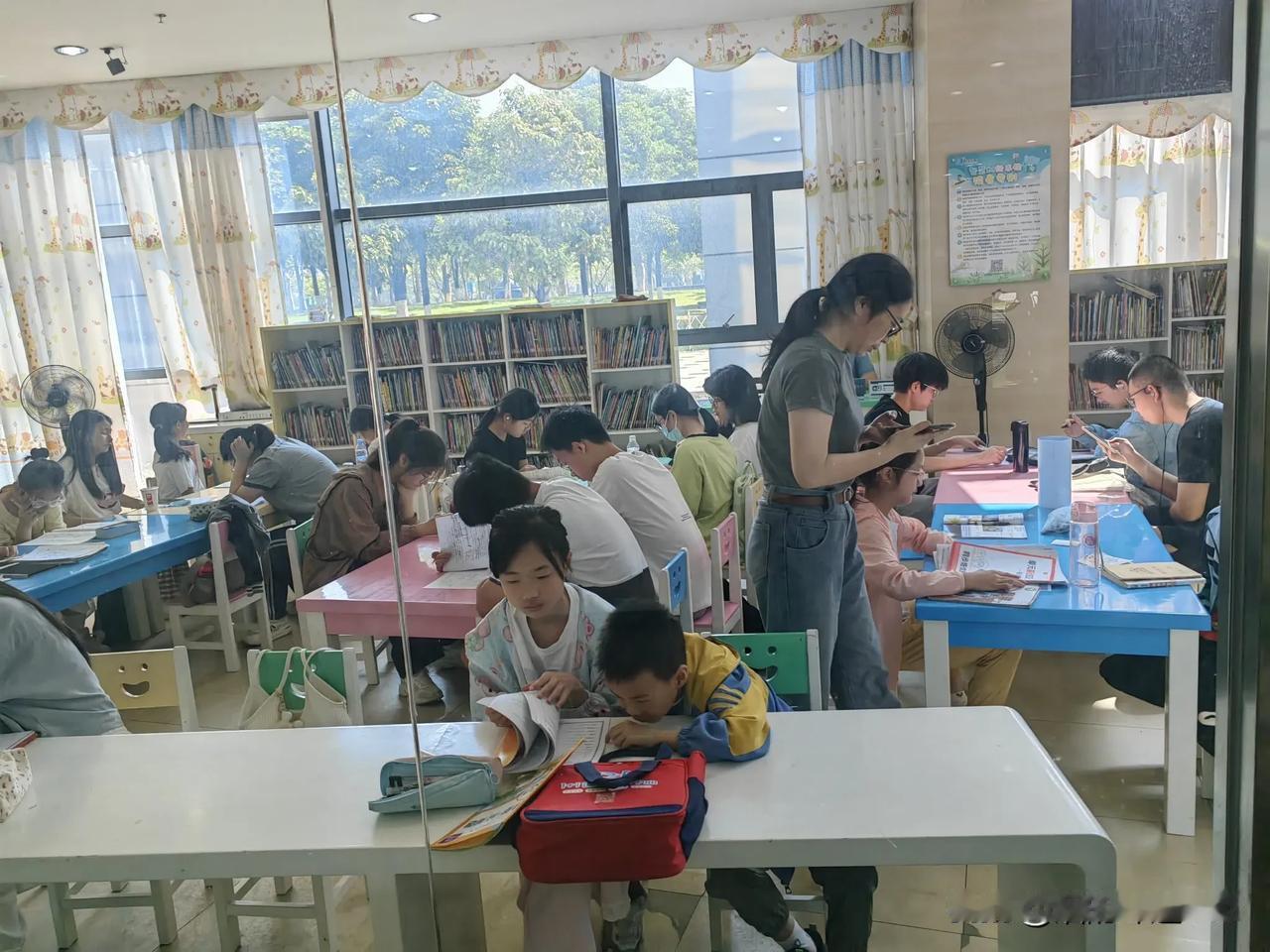 阳光洒进图书馆，节日中孩子们专心学习，书香满溢…