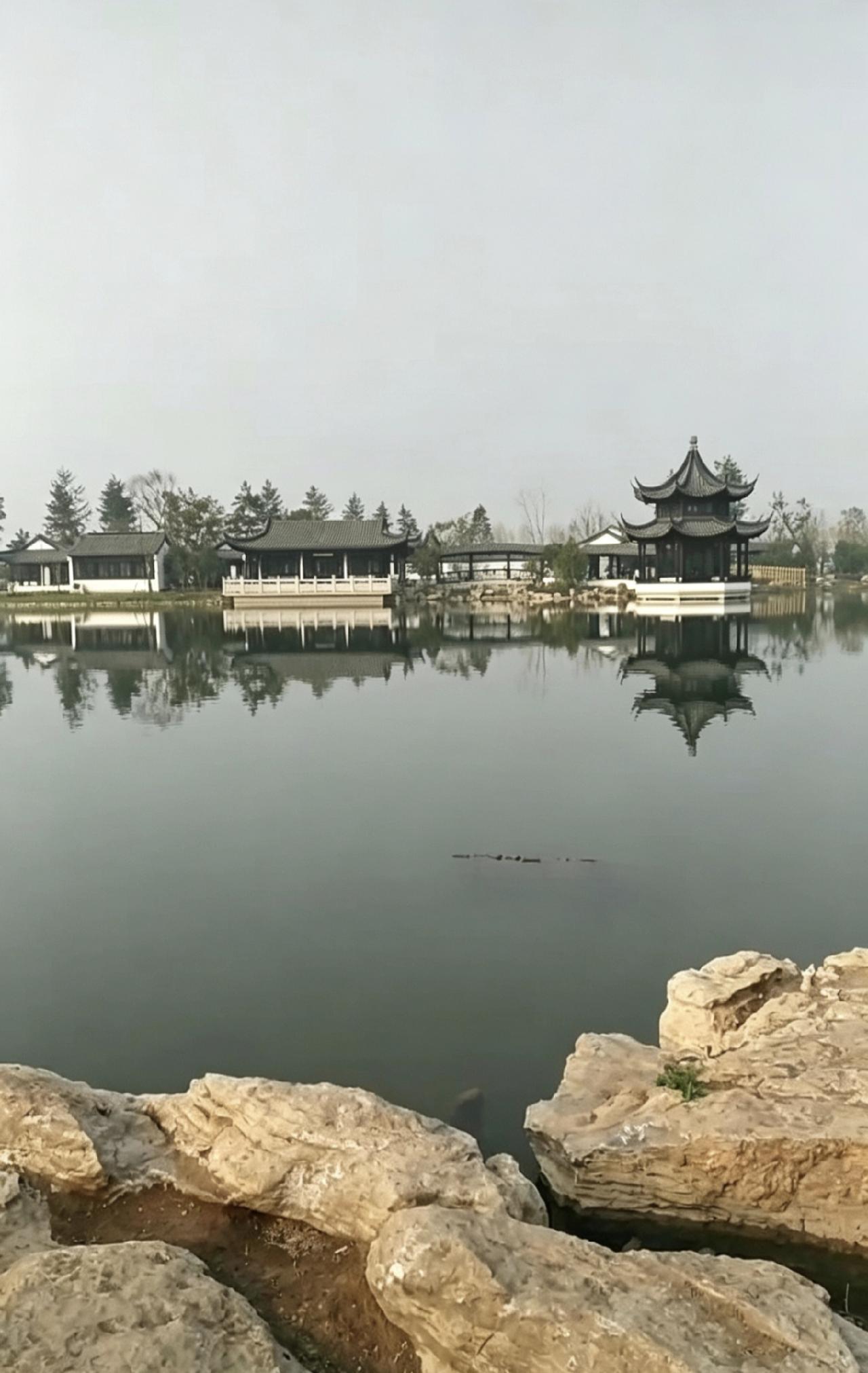 刚路过这片园子就被迷住了。黑瓦白墙的亭台倒映在湖面上，风都慢了下来。没有喧闹，只