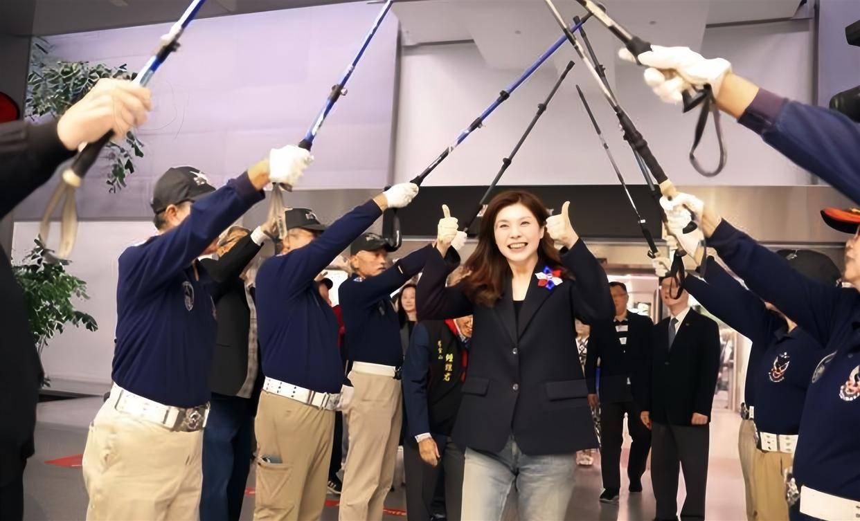 笑不活了！郑丽文接机现场，大爷们举着鱼竿搭“剑门礼”，这群大爷们的阵仗属实有点丐