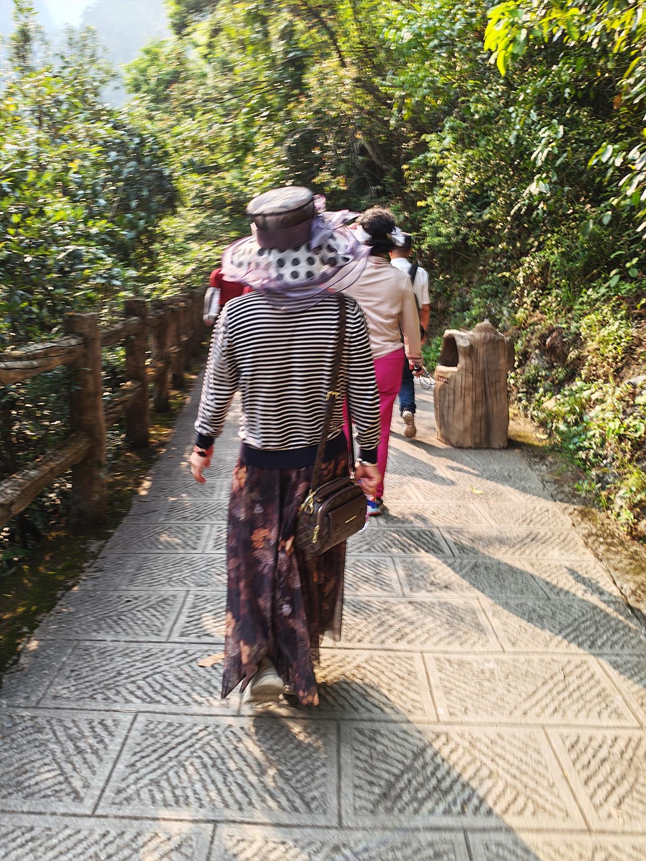 贵州之行。这是我们旅行团里的一位女士。她穿着时髦，迈着轻盈的步伐，好多人一会就被