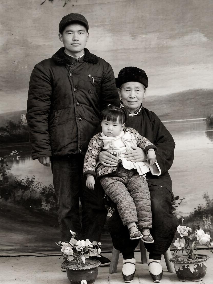 上世纪五十年代，一家三代人的合影。年迈的老祖母坐在凳子上，怀里抱着年幼的小孙女，