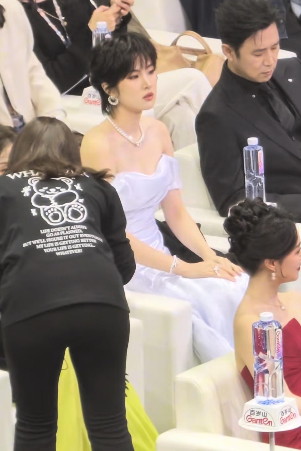 几个人坐在椅子上，旁边有工作人员在服务。