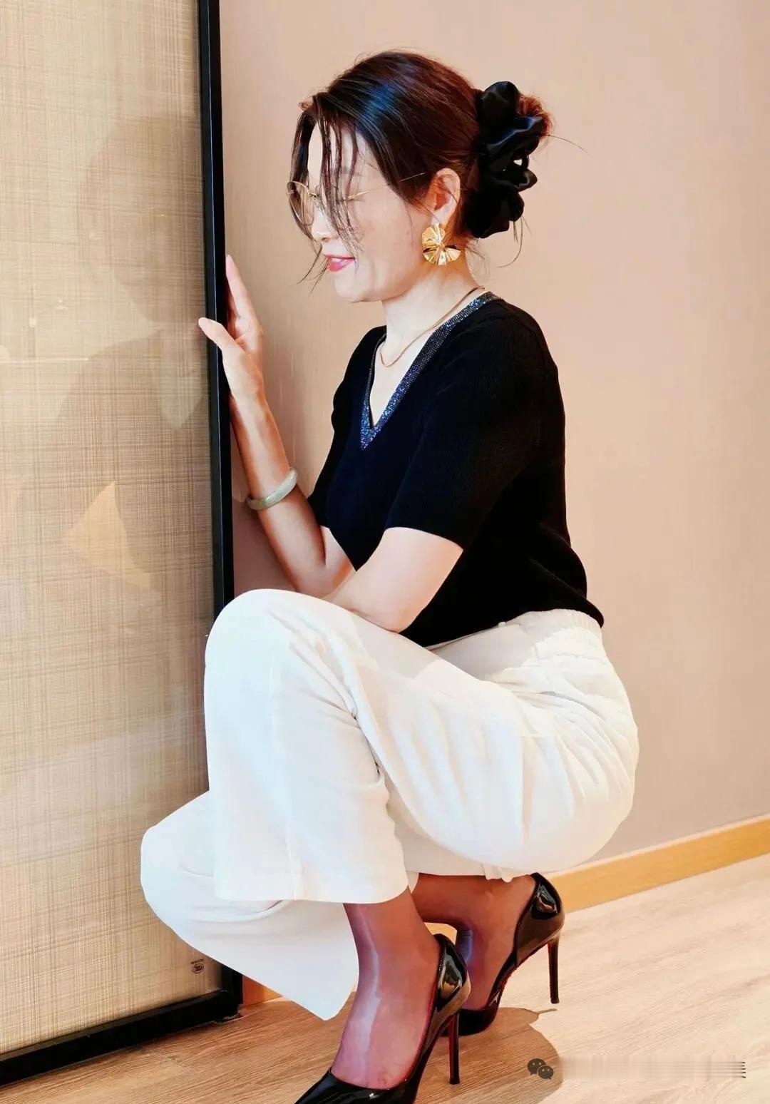这位女士在墙边摆了个姿势。