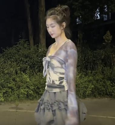 女子一身利落劲装，身姿挺拔站在开阔场地，手中九节鞭铁环碰撞，清脆声响震人心神。起