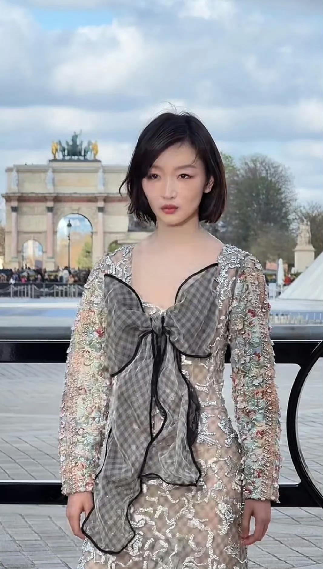 周冬雨亮相巴黎LV大秀，透视刺绣裙配巨型格纹蝴蝶结的造型引发两极评价：
有人吐槽