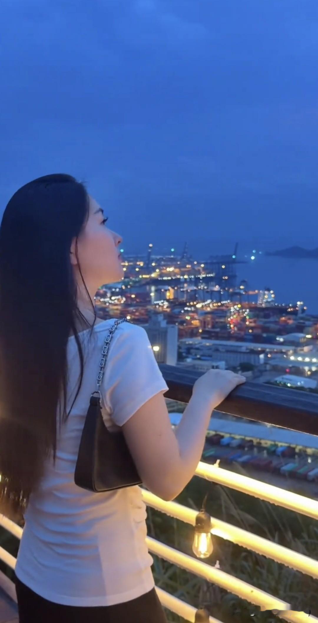 七绝·凭栏晚望
文/刚柔
 
暮色凝蓝覆港湾，千灯错落映尘寰。
凭栏静对江头景，