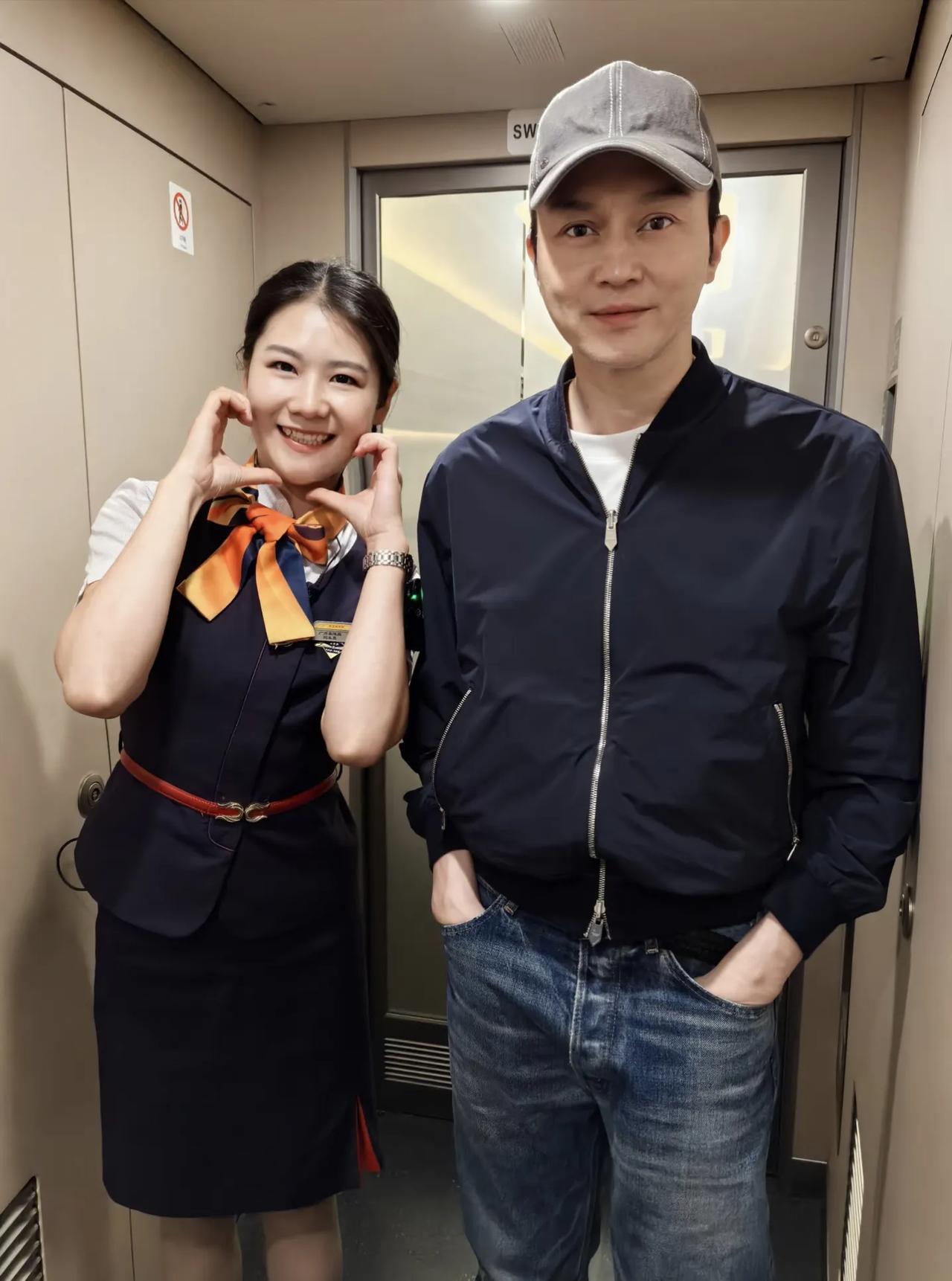 54岁张智霖坐高铁出行，和乘务员美女拍摄了合照。他的状态太好了，皮肤很白，很少皱