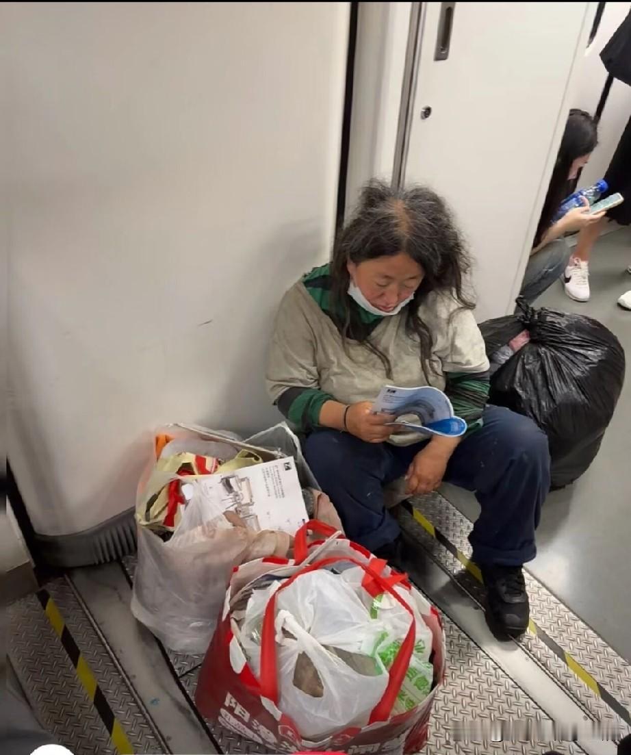 她是不是在遗憾当年车上人来人往，她低头沉迷书中。
一头乱发，满脸沧桑，和手里的书