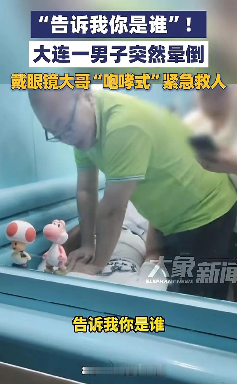 辽宁大连，男子突然晕倒。一位戴着眼镜的大哥，在给他做心肺复苏的同时，大声询问男子