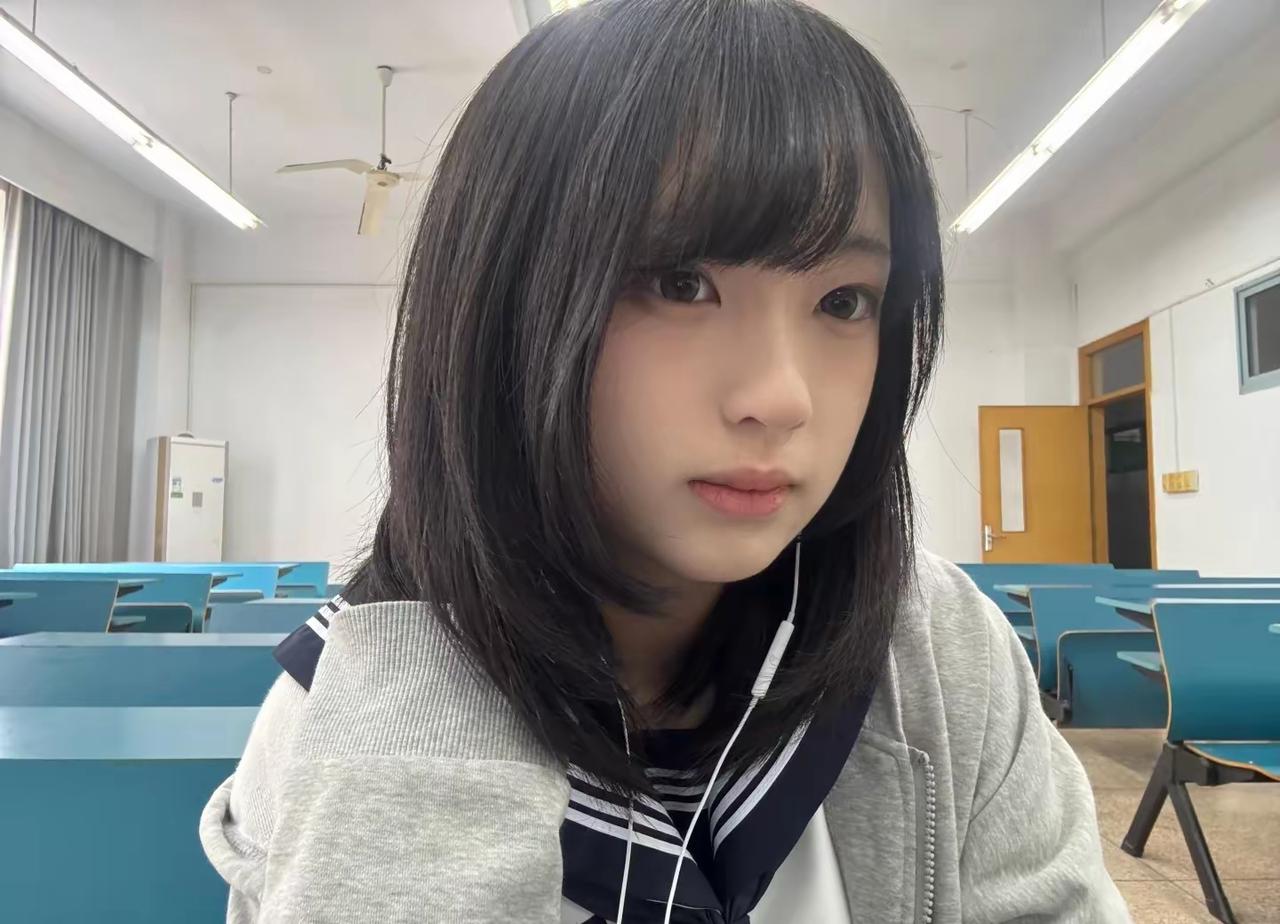 教室里坐着一个戴耳机的女生。带耳机美少女 校园里的小女孩 带着耳机的少女