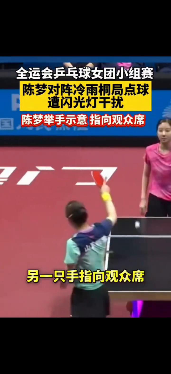 全运会乒乓球女团小组赛陈梦对阵冷雨桐局点球遭闪光灯干扰，陈梦举手示意指向观众席。