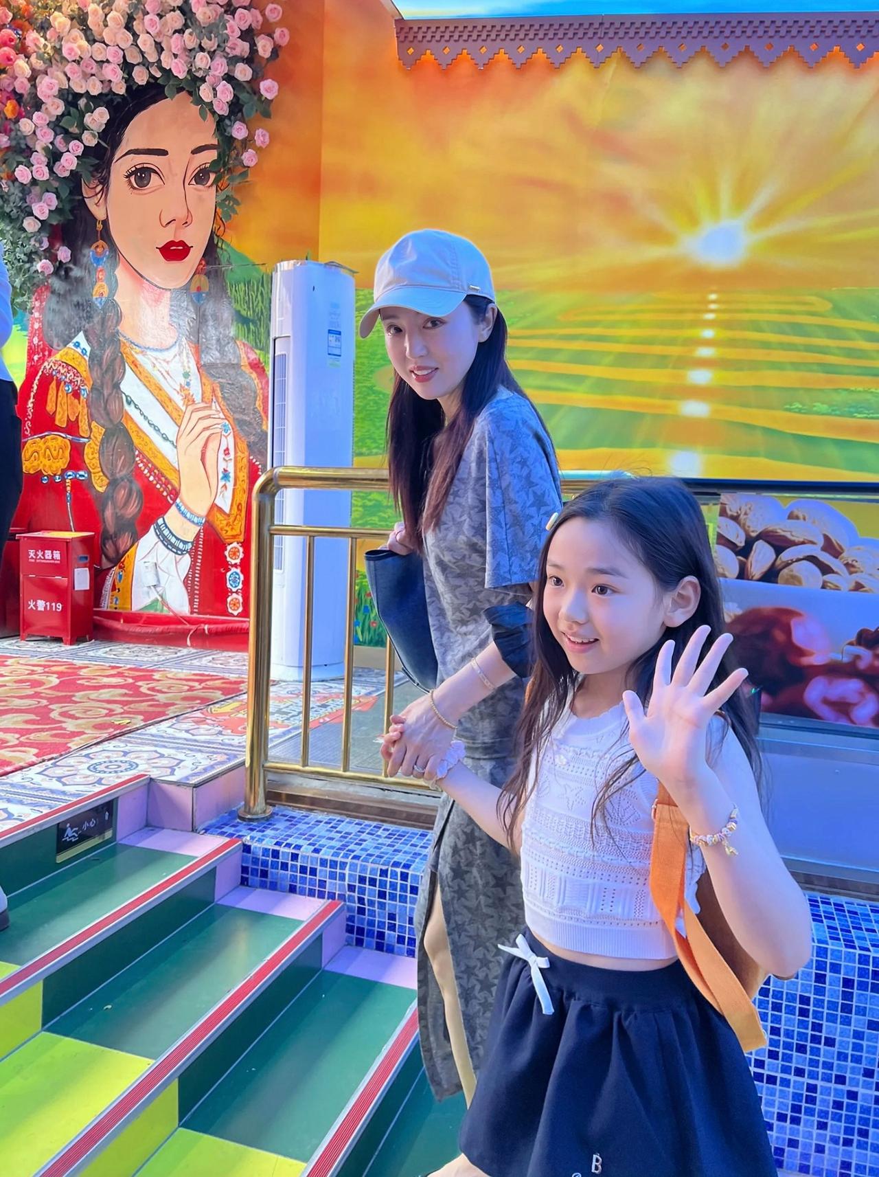 近日，董璇带着女儿现身新疆大巴扎，9岁小酒窝面对镜头，礼貌挥手的样子，好有明星范