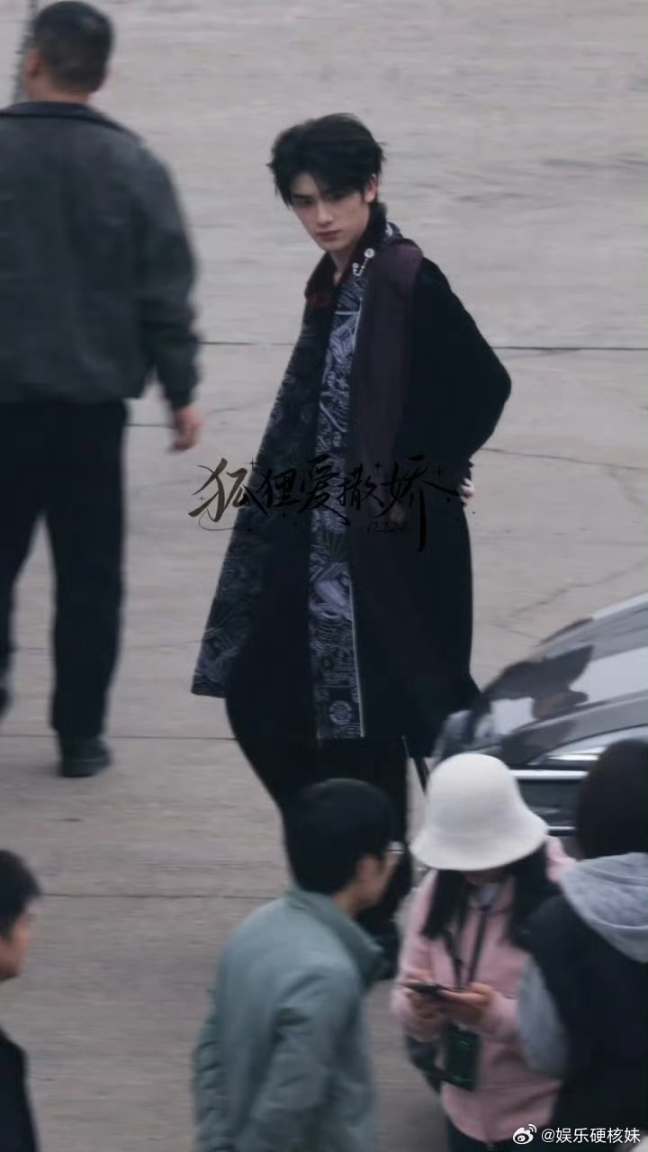 雨中的丁程鑫穿白色西装，撑着伞和粉丝打招呼，一边走一边互动，活脱脱接公主回家的王