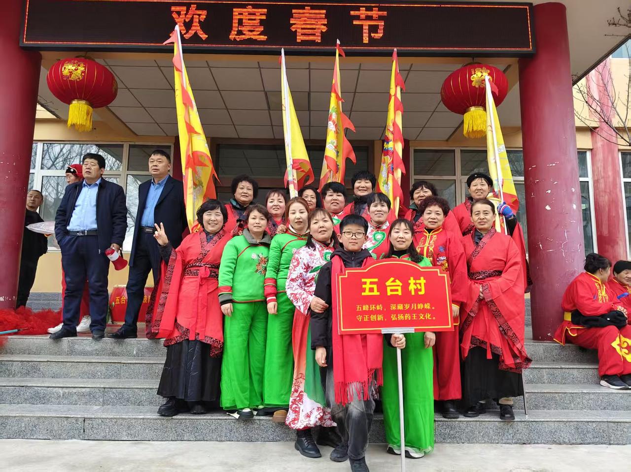 2. 红妆映古村，彩旗耀新春。五台村儿女身着盛装，以非遗之韵赴新春之约，让千年文