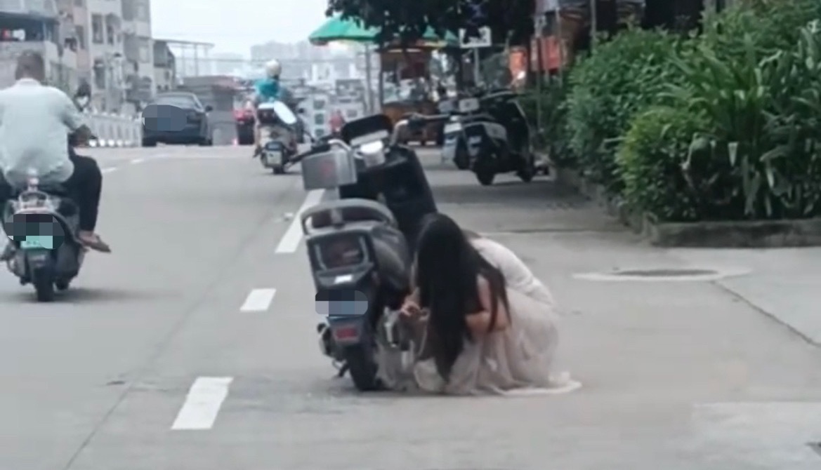 【玉林北流女子骑电车长裙被卷进轮毂里】7月31日，玉林市北流一名女子穿长裙骑电动