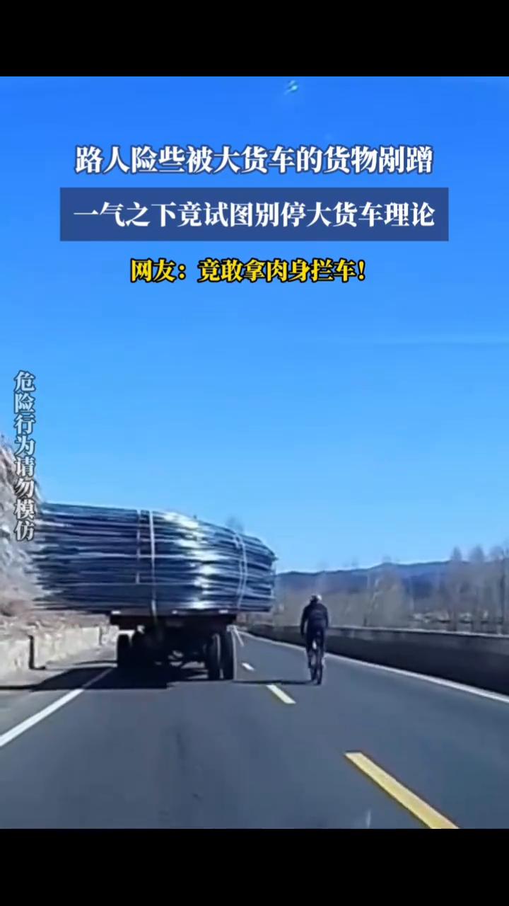 路人险些被大货车的货物刚蹭，气之下竟试图别停大货车理论。网友：竟敢拿肉身拦车！