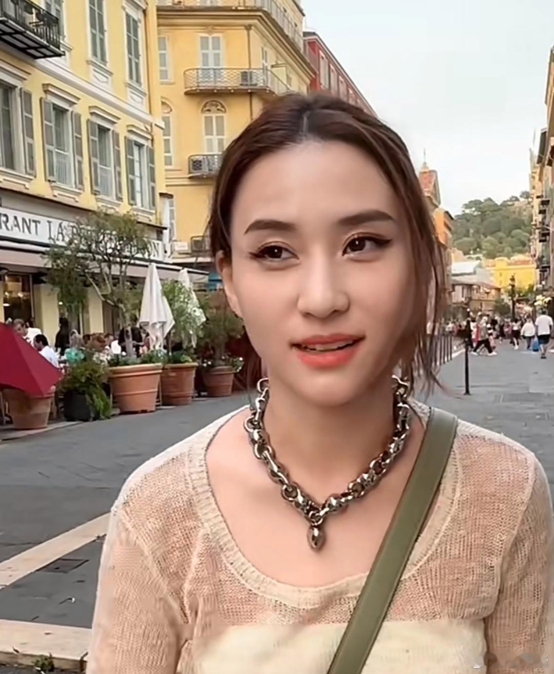何超莲戴大项链拍视频，豪门千金气质独一无二。街头摆pose自在开心，妆容浓衣时尚