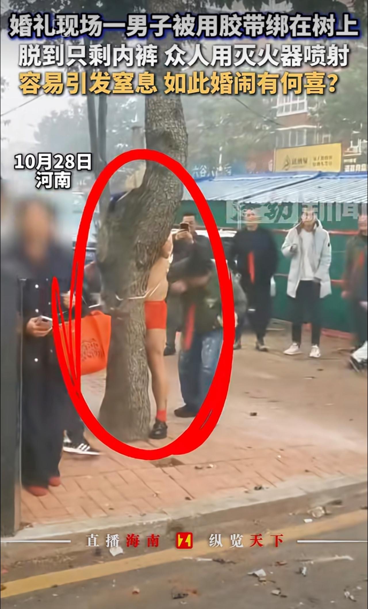 婚礼现场一男子被用胶带绑在树上，脱到只剩内裤 众人用灭火器喷射，容易引发窒息 如