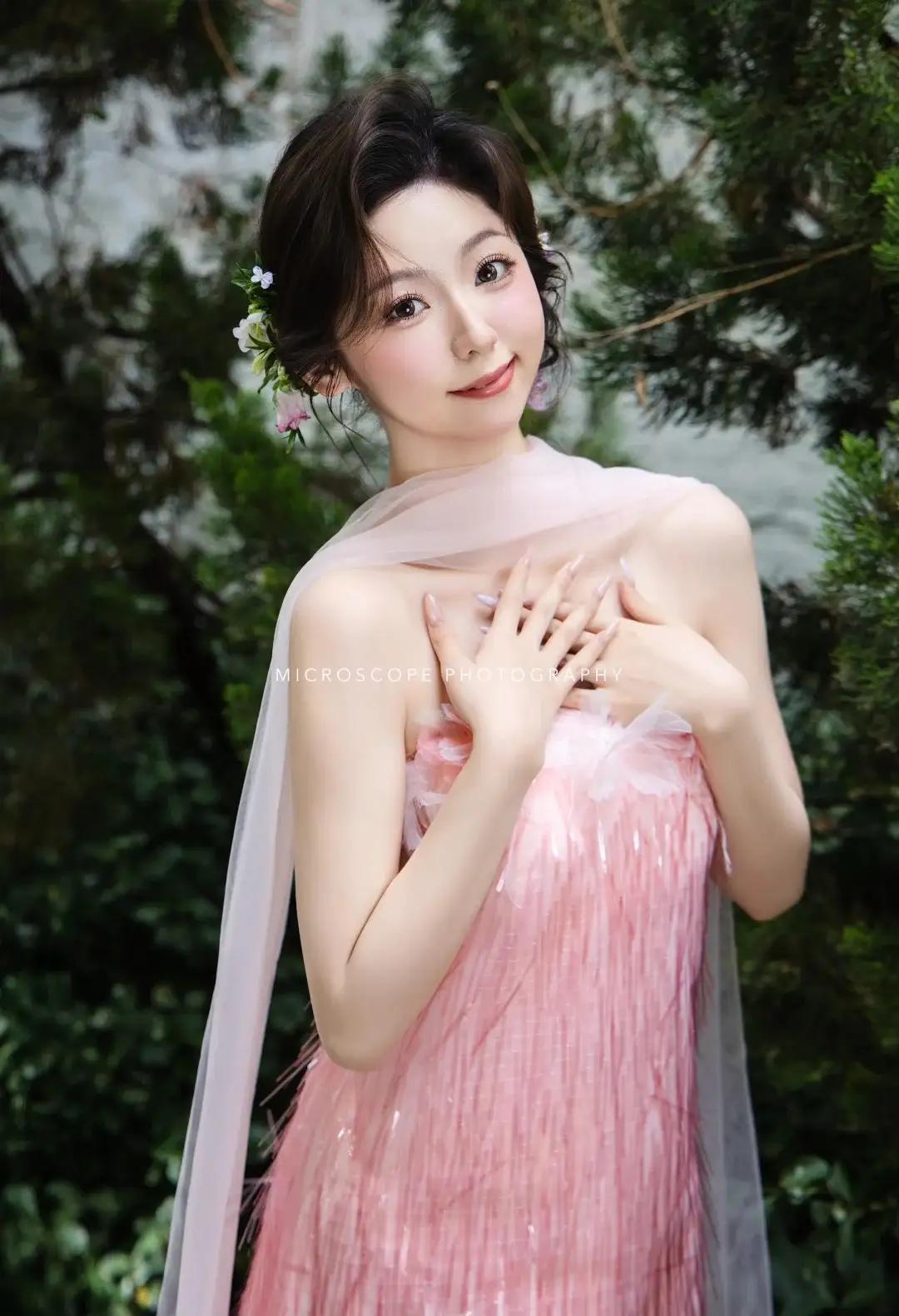 暮春的薄雾尚未散尽，阳光穿过榉木枝叶的间隙，在她藕粉色的缎面裙摆上织出细碎光斑。