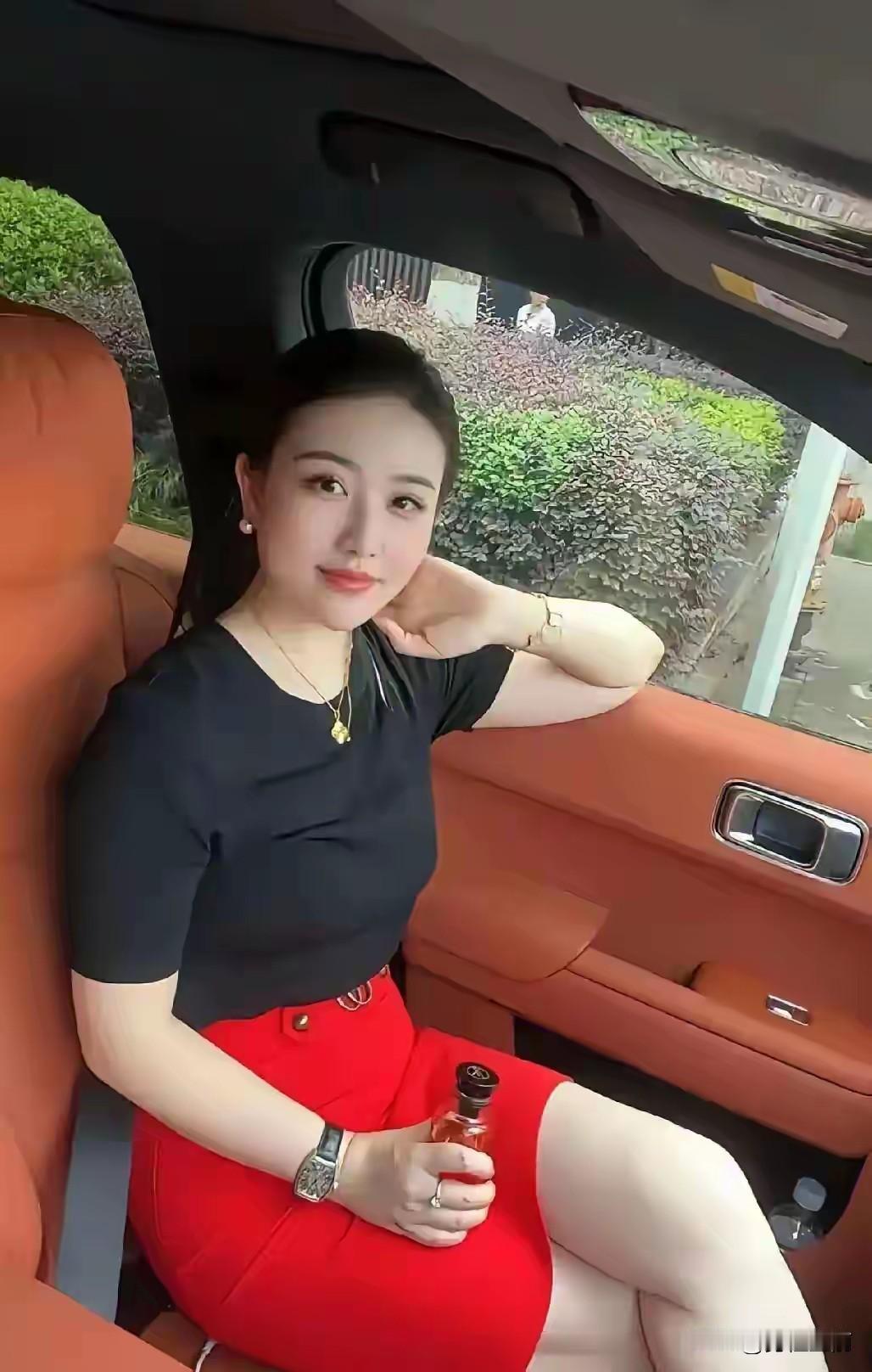 美女坐在车里，手拿香水，心情不错。