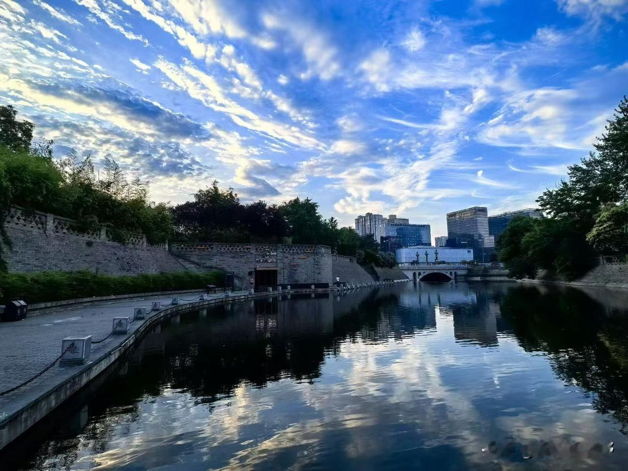 静谧的河岸，倒映着云彩与城市，仿佛置身世外桃源。