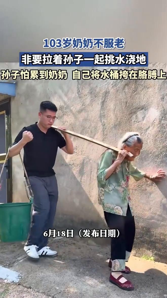 103岁奶奶不服老，非要拉着孙子一起挑水浇地。孙子怕累到奶奶自己将水桶挎在胳膊上