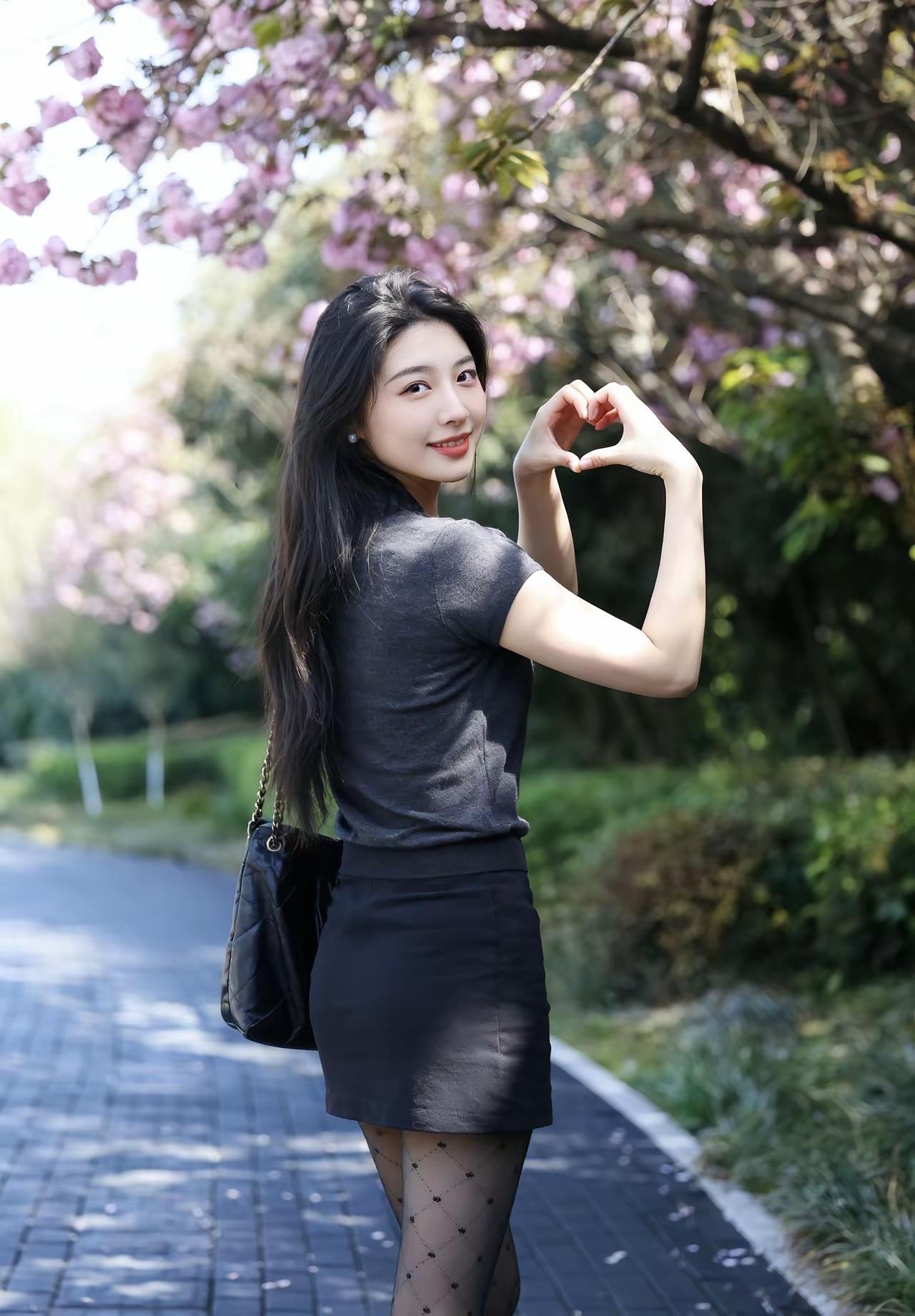 樱花树下，少女心满满，微笑比心，春日美好时光。