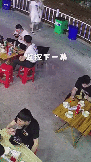 男子正在街头吃面。
他面前的桌子突然崩塌解体？
这直接把男子给看懵了？