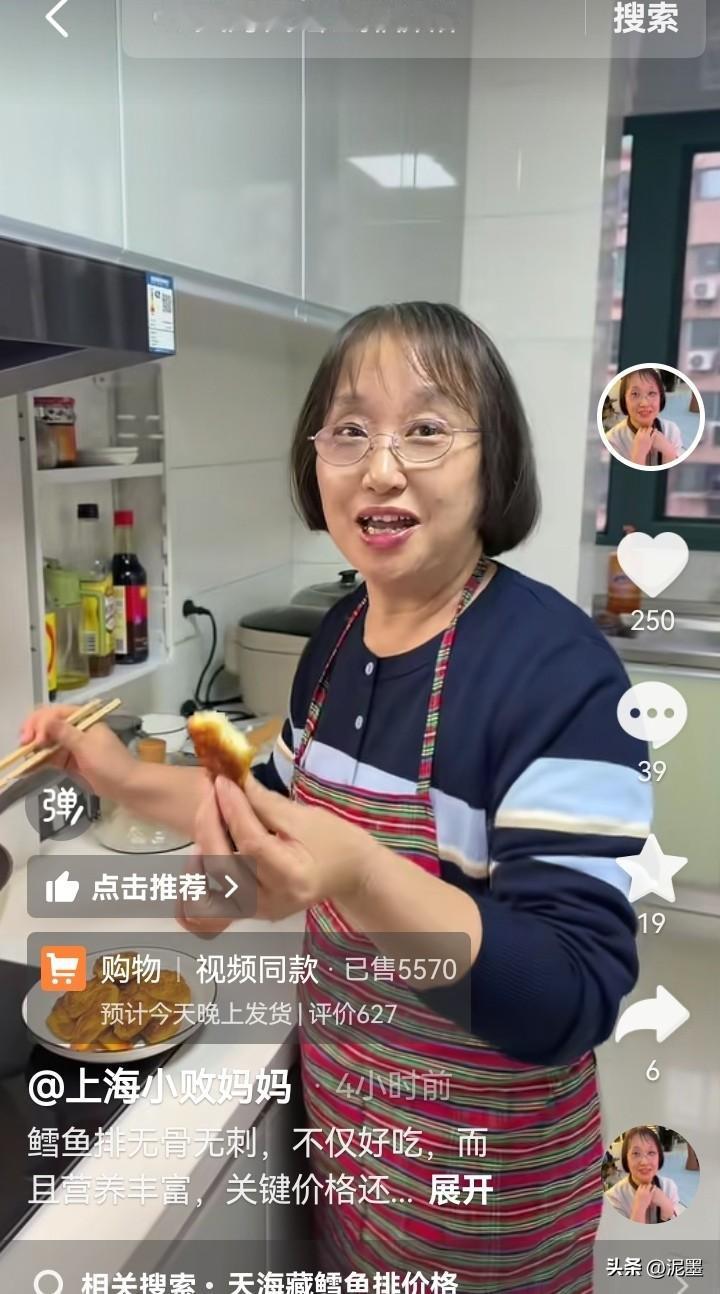 上海小败妈妈站在灶台前，她身穿深蓝色带条纹的上衣，系着一条红白格纹的围裙，脚上穿